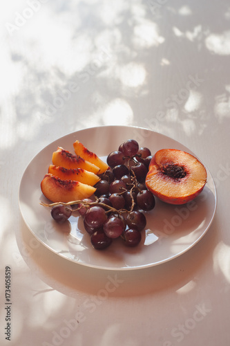 Peach and Grapes on White Plate with Floral Shadows, Sardinia, Vertical Close Up with Copy Space
