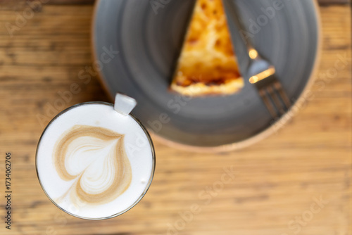 Latte Macchiato mit Latte Art Herz und Kuchen von oben