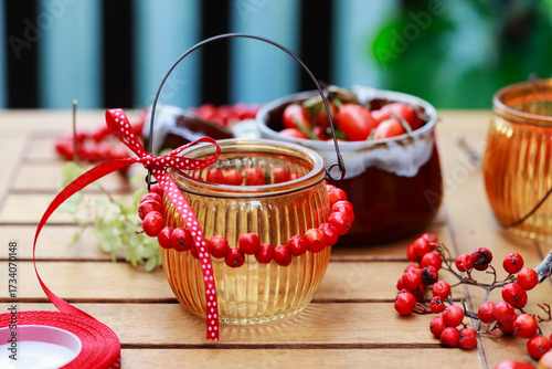 Florist at work: woman making decorations with rowan berry and rosehip.