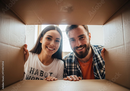 Excited young couple unpacking belongings in new home creates happy memories together, smiling brightly with anticipation for their future life