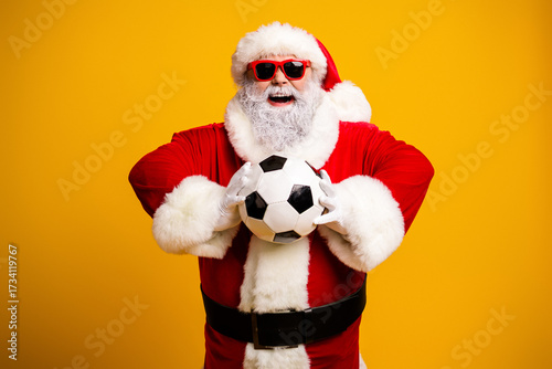 Santa Claus in festive attire happily holding a soccer ball, radiating holiday cheer, fun vibes, and Christmas spirit