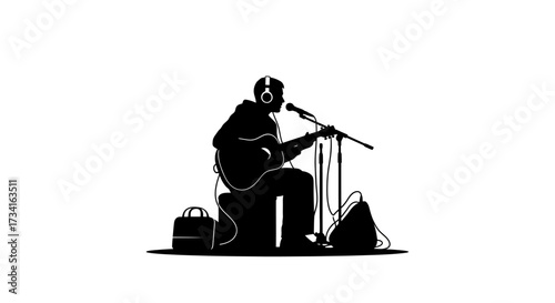 Musician practices singing and guitar with headphones and microphones in silhouette