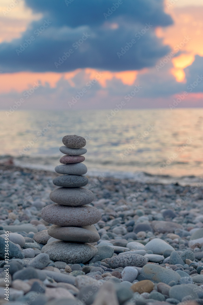 Fototapeta premium Cairn made of pebbles on the sea shore. Abstract