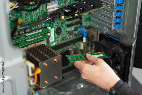 Canvas Print Male IT technician installs RAM module in server during hardware upgrade and mai