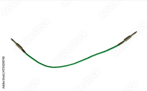 Green audio jack cable with metal connectors for musical instruments and sound equipment isolated on white background