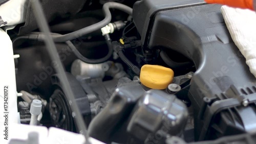 Gloves mechanic man checking car engine oil with dipstick