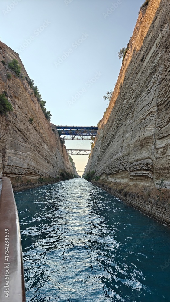 Fototapeta premium Sailing among the giant walls of the Corinth Canal in the Greek Mediterranean Sea
