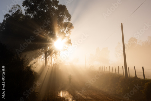 Papier peint Ciclista de Mountainbike subindo estrada de terra com nevoa