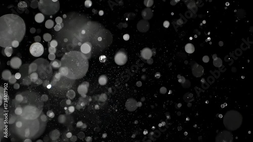 Black background with white blurred circles, resembling bubbles or floating particles