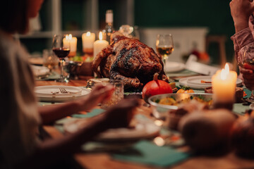 Family celebrating thanksgiving enjoying roasted turkey dinner at home
