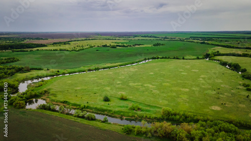 aerial landscape of a river and a green field