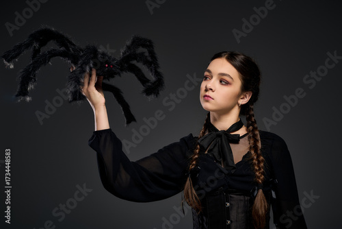 Wallpaper Mural Girl in gothic dress portrays Halloween character with spooky spider prop Torontodigital.ca