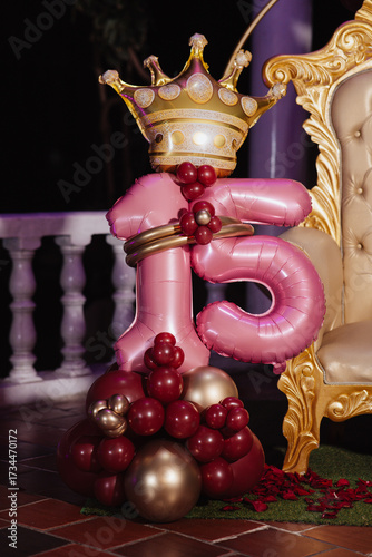 number 15 balloons next to a throne-style chair
