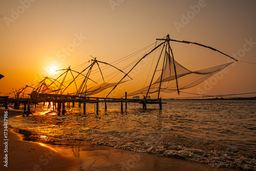 Foto March 25, 2016, in Kochi, India, the iconic Chinese fishing nets stand tall against a glowing sunset