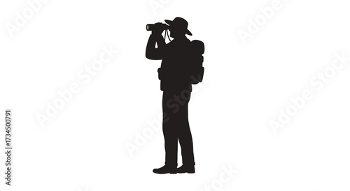 A hiker with backpack looking through binoculars a dark form silhouette