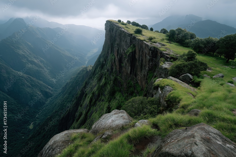 Fototapeta premium Green mountain cliff overlooking vast misty valley