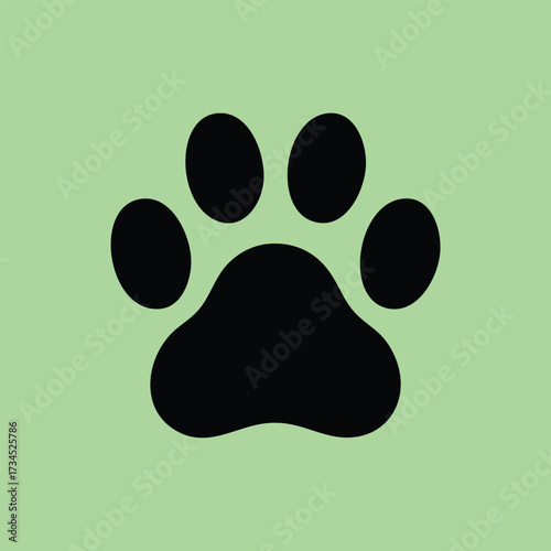 Close-up of a black paw print symbol on a soft green emphasizing animal tracks and wildlife footprints