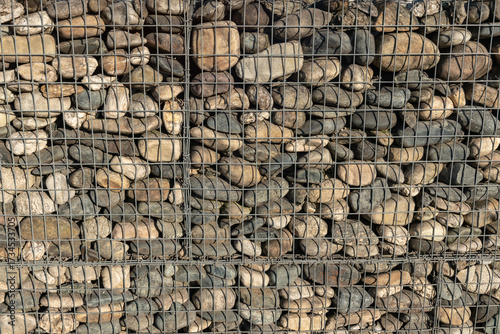 Natural stone wall with metal retaining grids, a proven technique for landslides and rocks, a protective barrier with low visual impact. Environmental safety architectural structure