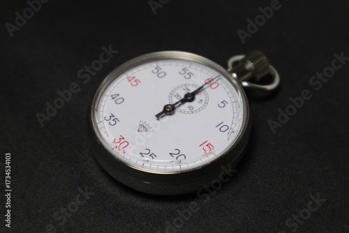 Vintage stopwatch resting on a dark textured surface showcasing precision measurement SPOK