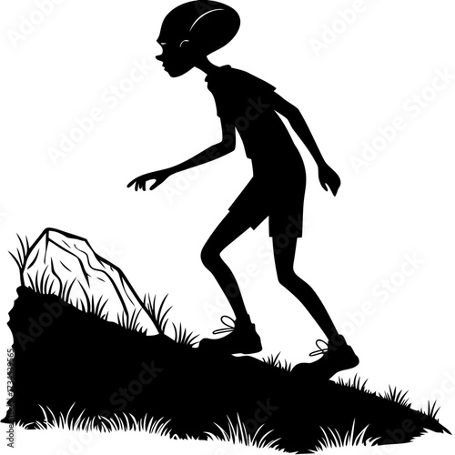 Silhouette of a child exploring a rocky hill with grass