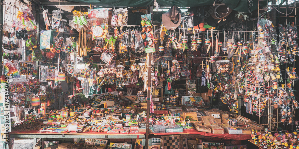 Fototapeta premium A densely packed curio shop filled with hanging Mexican trinkets, dolls, keychains, and souvenirs. This image captures the colorful chaos of a traditional marketplace in Mexico.