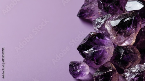 Amethyst gemstones pile on purple surface with copy space for design