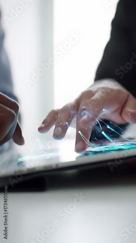 Close-up video of diverse professional hands interacting with a glowing futuristic interface. Luminous data streams flow, brightly lit. Concept of innovation and seamless connectivity.