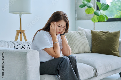 Mature sad woman experiencing stress, mental and physical pain, at home