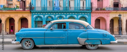 Classic blue American car parked near colorful buildings in the city