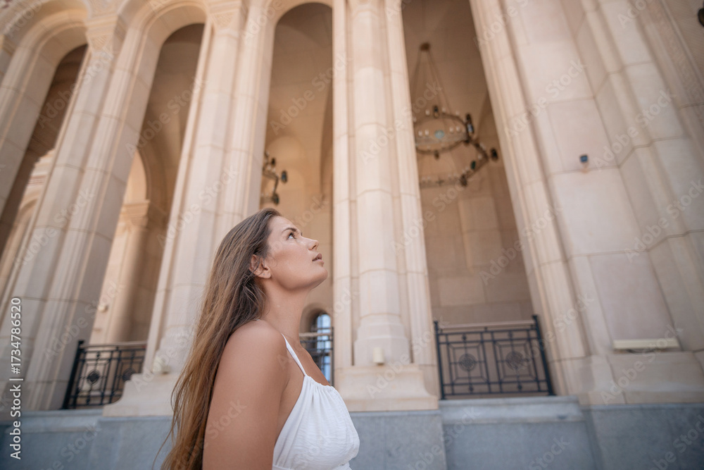 Fototapeta premium Woman, architecture, building, looking up at grand columns and arches with wonder.