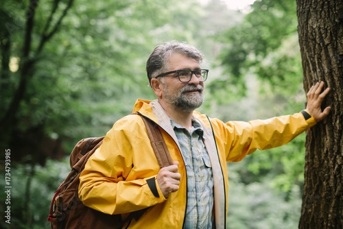 Mature man enjoying nature in green forest