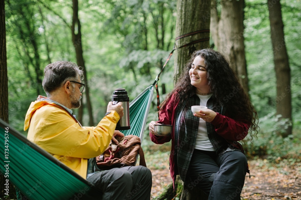 Naklejka premium Father daughter resting outdoors enjoying a warm drink