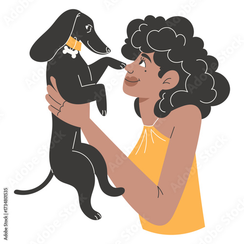 Person holding a black dachshund with a yellow collar