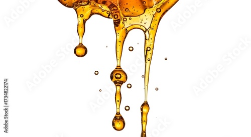 Close up of dripping golden liquid against a white background