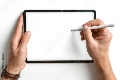 Overhead view of a person's hands holding a modern digital tablet with a blank white screen and a stylus pen.