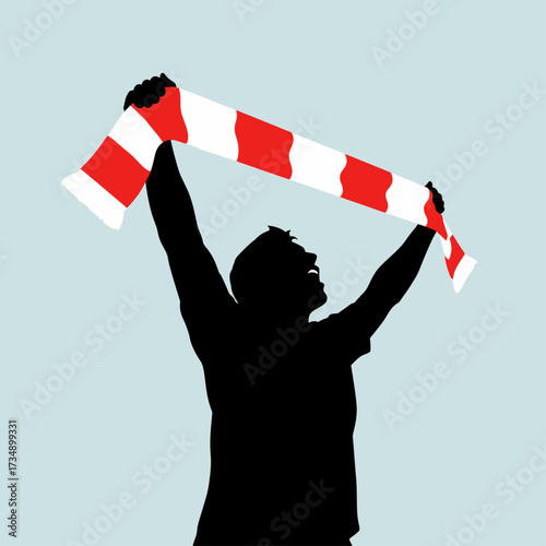 Silhouette of a sports fan celebrating, holding a red and white striped scarf high in the air.