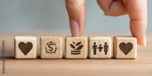Hand placing wooden blocks with symbols of love, money, growth, and family