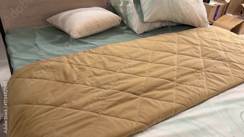 cozy bed with pillows and quilted comforter in bed