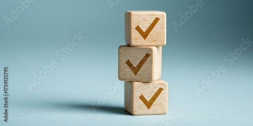 Three wooden cubes stacked vertically, each bearing a gold-colored checkmark