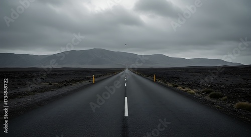 Road leading toward mountains under a cloudy sky