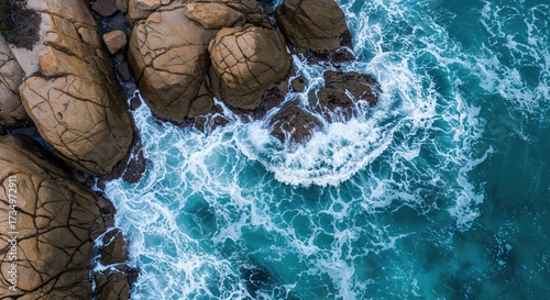 Coastal Harmony:  A striking aerial view captures the raw power and beauty of the ocean's embrace with rugged coastline, creating an enchanting scene of natural allure.