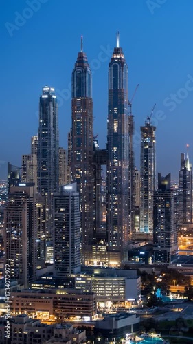 Wallpaper Mural Dusk cityscape with illuminated towering skyscrapers, some under construction, against a deep blue sky Torontodigital.ca