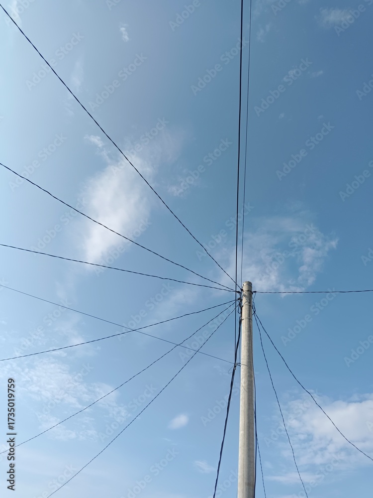 Fototapeta premium Electric pole connect with wires with blue sky as background