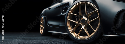 close-up of a gold rim luxury supercar wheel isolated against a dark background, captured in black and white banner format with room for copy, emphasizing automotive design and modern performance