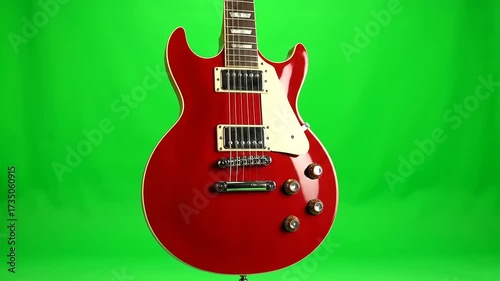 Close-up of a Classic Red Electric Guitar Rotating Slowly on a Chroma Key Green Screen Background