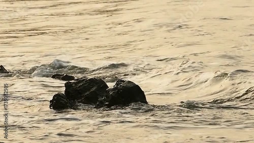 Ocean Waves Crashing Against Small Rocks on the Shore