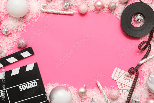 Composition with movie clapper and Christmas decorations on pink background. ...