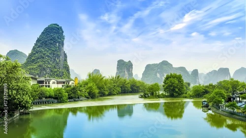 Karst Mountains Reflected In Calm River Under Blue Sky