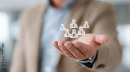 Supporting the Team: A person's outstretched hand gently cradles a collection of small icon figures representing the team, team support and unity.
