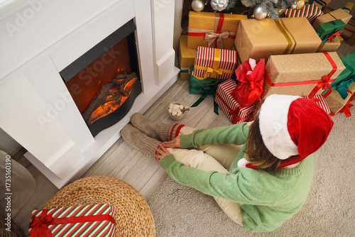 Young woman in Santa hat si...